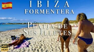 Topless woman on beach walk in Ibiza