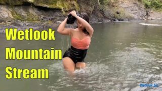 Wetlook girl get wet in mountain stream in skirt and tights