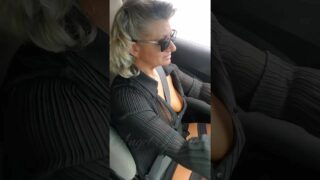 Downblouse view of hot milf driving her car, and with a very naughty look at the camera once in a while