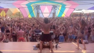 0:36 busty topless in left side in the crowd, 1:55 in the middle and in the middle right hippie girls